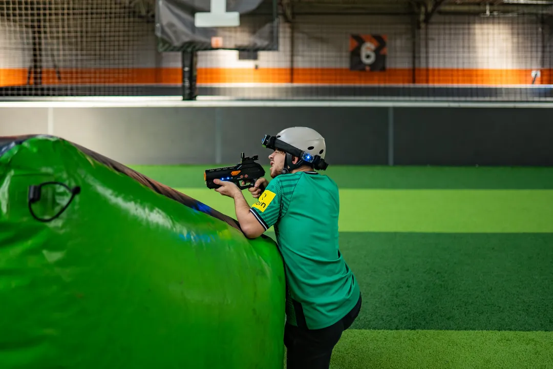 Joueur de Laser Game à couvert derrière un obstacle gonflable