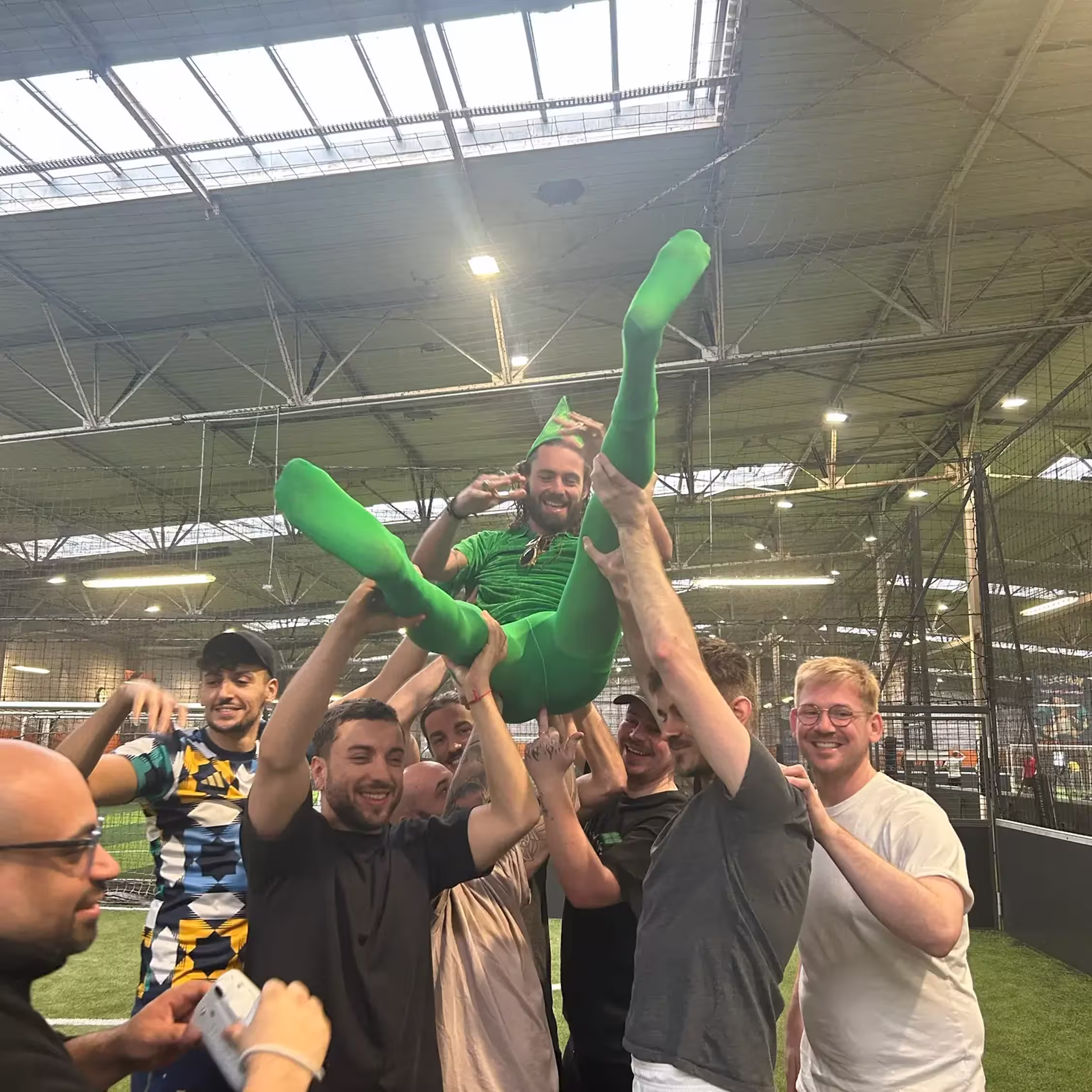 Participants soulevant le futur marié après une partie de Bubble Foot