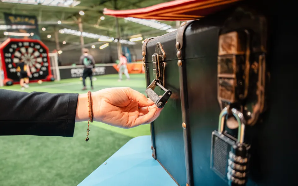 Main ouvrant une malle d’Escape Game UniGames avec un cadenas