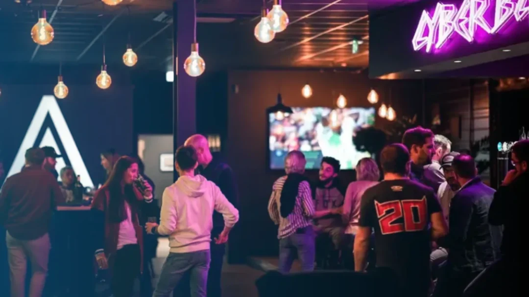 Des personnes échangent dans un espace de bar éclairé de lumières colorées